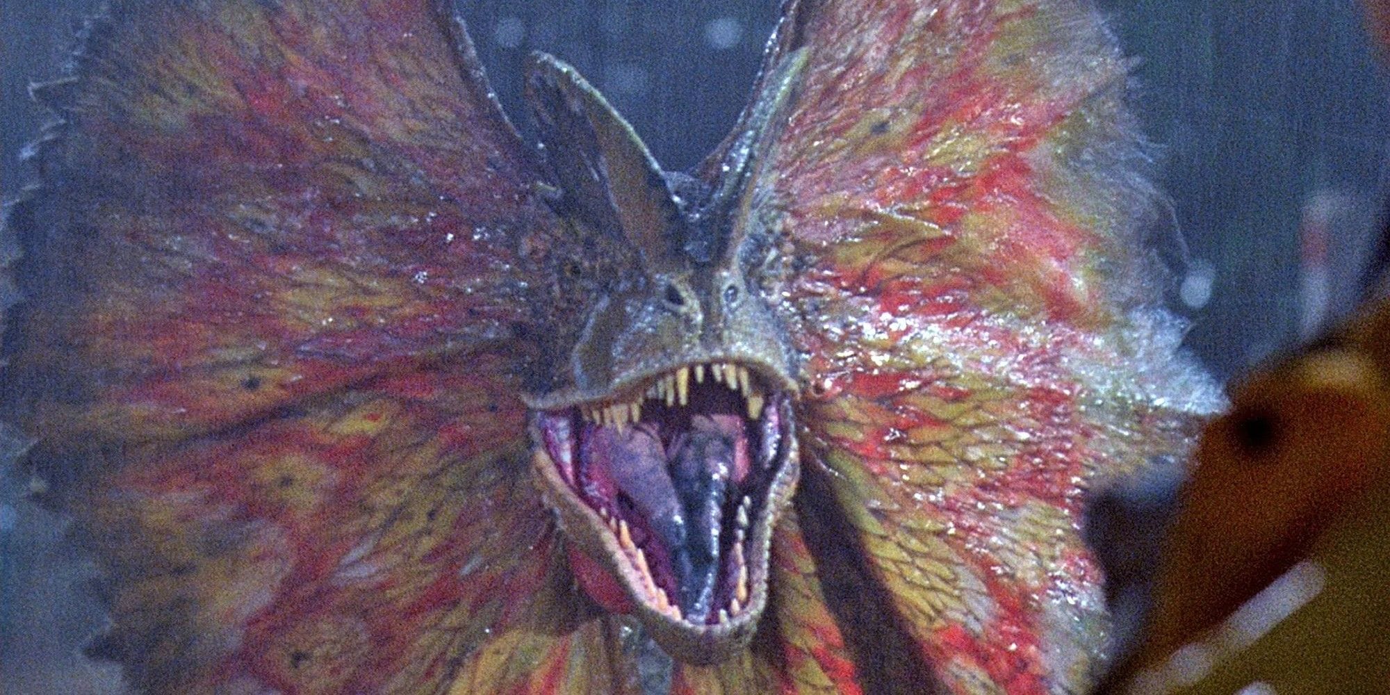 A still from the movie Jurassic Park, showing the Dilophosaurus hissing with its neck frills spread.